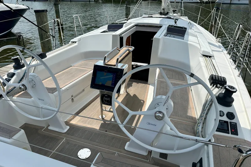 Slide: The Image of 2021 Hanse 348 sailboat cockpit with dual steering wheels and navigation display. - 9