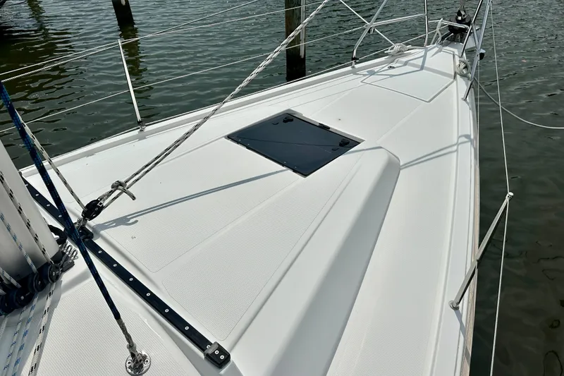 Slide: The Image of 2021 Hanse 348 sailboat deck with ropes and hatch, docked on calm water. - 18
