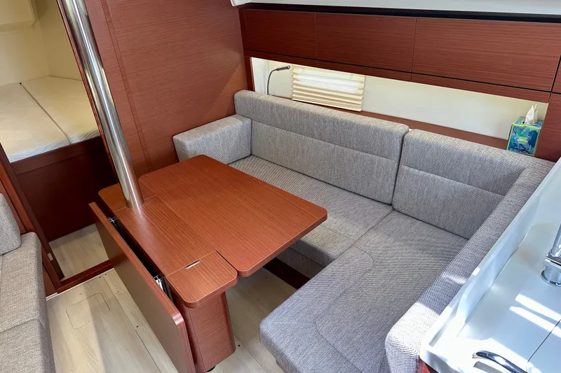 Slide: The Image of Interior of 2021 Hanse 348 yacht with cozy seating and wooden table. - 22