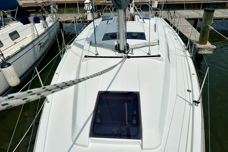 Slide: The Image of 2021 Hanse 348 sailboat docked at marina, showcasing sleek deck design. - 19