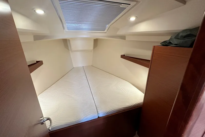 Slide: The Image of Interior cabin of 2021 Hanse 348 yacht with cozy bedding and wooden shelves. - 26