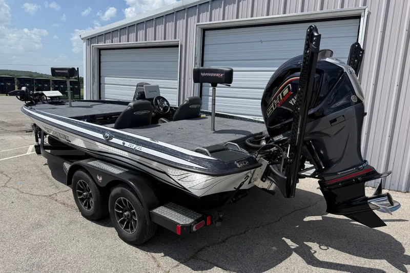 Slide: The Image of 2027 Phoenix 721 ZXL boat with Yamaha engine parked near a metal building. - 2