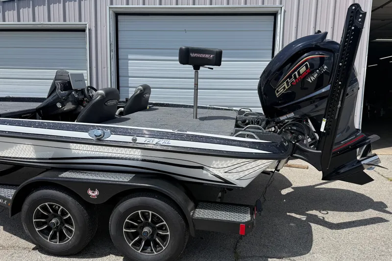 Slide: The Image of 2027 Phoenix 721 ZXL boat with Yamaha engine, parked outside a garage. - 4