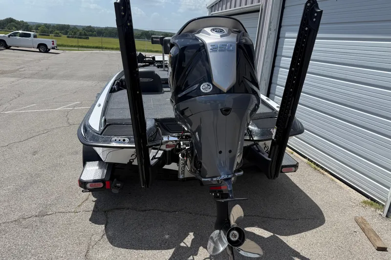 Slide: The Image of 2027 Phoenix 721 ZXL boat with powerful outboard motor, parked near a metal building. - 5