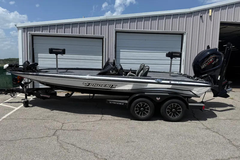 The Image of 2027 Phoenix 721 ZXL boat parked outside a garage on a sunny day. - 1