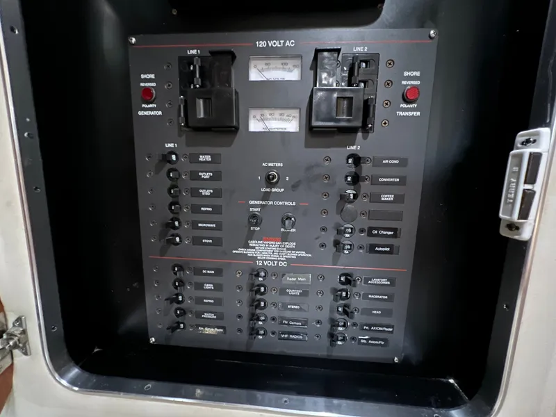 Slide: The Image of Electrical control panel on a 2004 Wellcraft 330 Coastal boat, featuring various switches and indicators. - 14