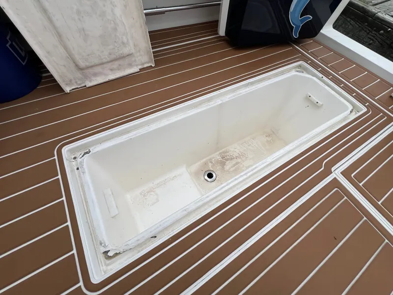 Slide: The Image of The image shows an open storage compartment on the deck of a 2004 Wellcraft 330 Coastal. - 22