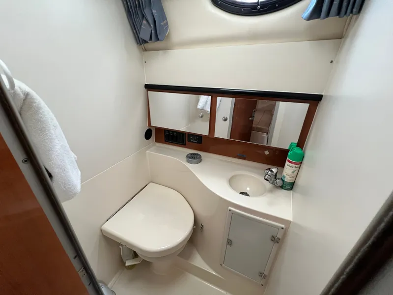 Slide: The Image of The image shows a boat bathroom with a toilet, sink, and mirror. - 15