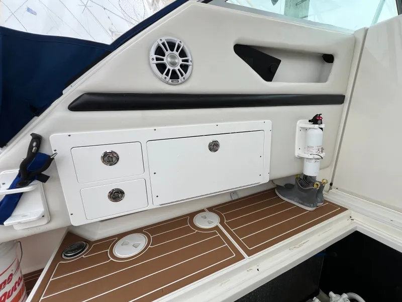 Slide: The Image of The image shows the cockpit of a 2004 Wellcraft 330 Coastal with storage and a speaker. - 20