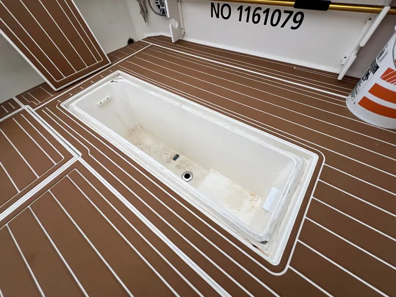 Slide: The Image of The image shows the deck of a 2004 Wellcraft 330 Coastal with a built-in storage compartment. - 23
