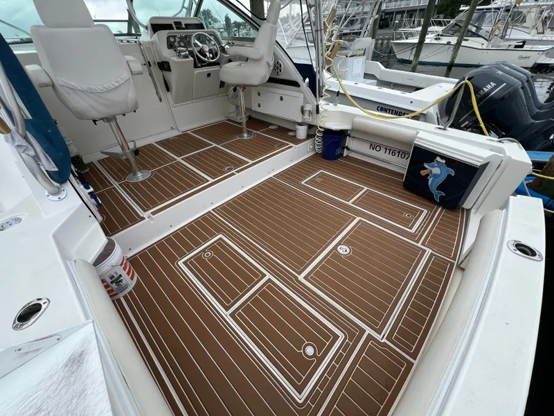Slide: The Image of The image shows the cockpit of a 2004 Wellcraft 330 Coastal with wood-patterned flooring. - 4
