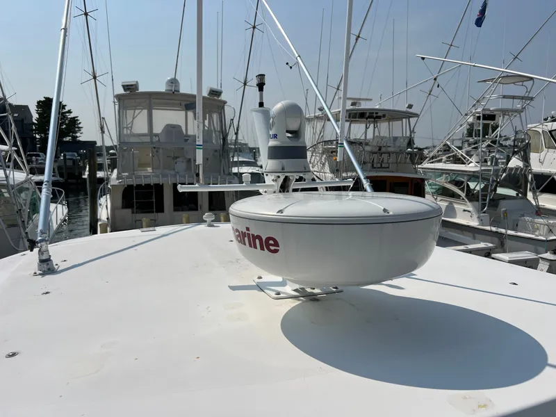 Slide: The Image of A 2004 Wellcraft 330 Coastal with radar equipment on the roof, surrounded by other boats in the marina. - 26