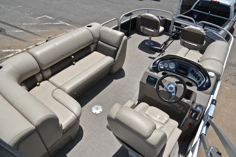 Slide: The Image of 2022 Sun Tracker Fishin' Barge 20 DLX interior with beige seating and steering console. - 19