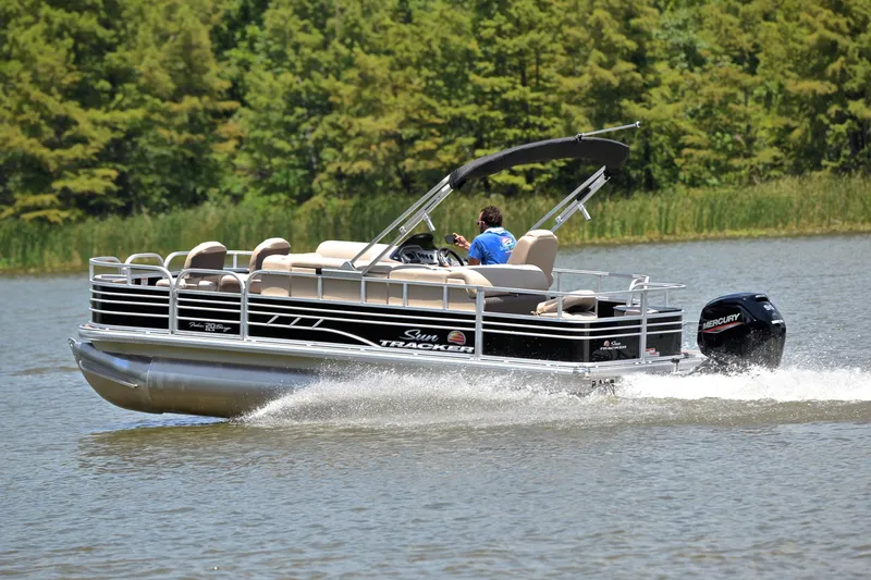 Slide: The Image of 2022 Sun Tracker Fishin' Barge 20 DLX pontoon boat cruising on a lake. - 4