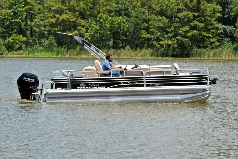 Slide: The Image of 2022 Sun Tracker Fishin' Barge 20 DLX pontoon boat cruising on a lake. - 6