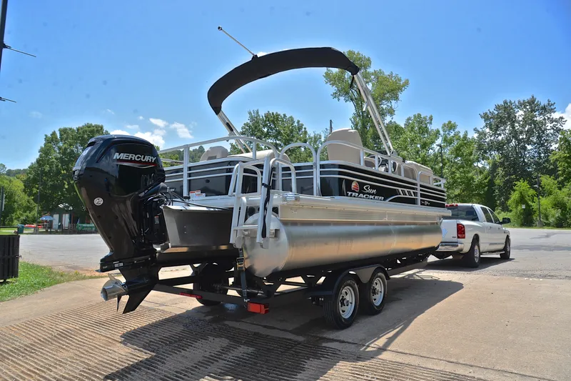 Slide: The Image of 2022 Sun Tracker Fishin' Barge 20 DLX pontoon boat on trailer, parked outdoors. - 14