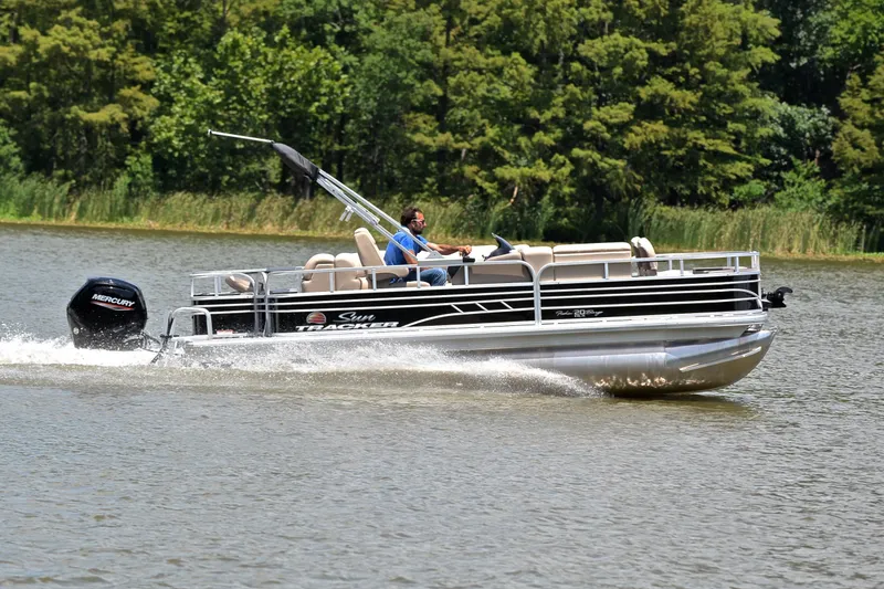 Slide: The Image of 2022 Sun Tracker Fishin' Barge 20 DLX cruising on a lake with lush greenery. - 3
