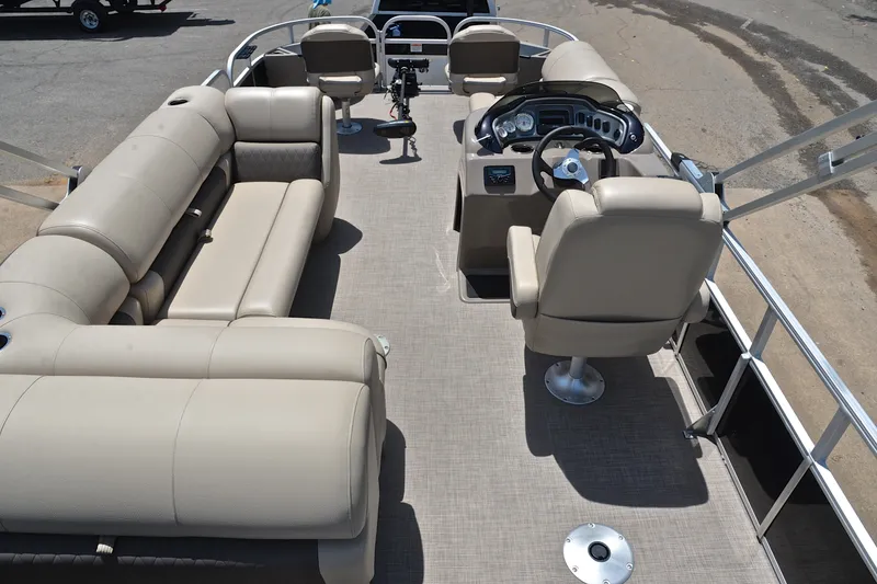Slide: The Image of 2022 Sun Tracker Fishin' Barge 20 DLX interior with beige seating and steering console. - 18