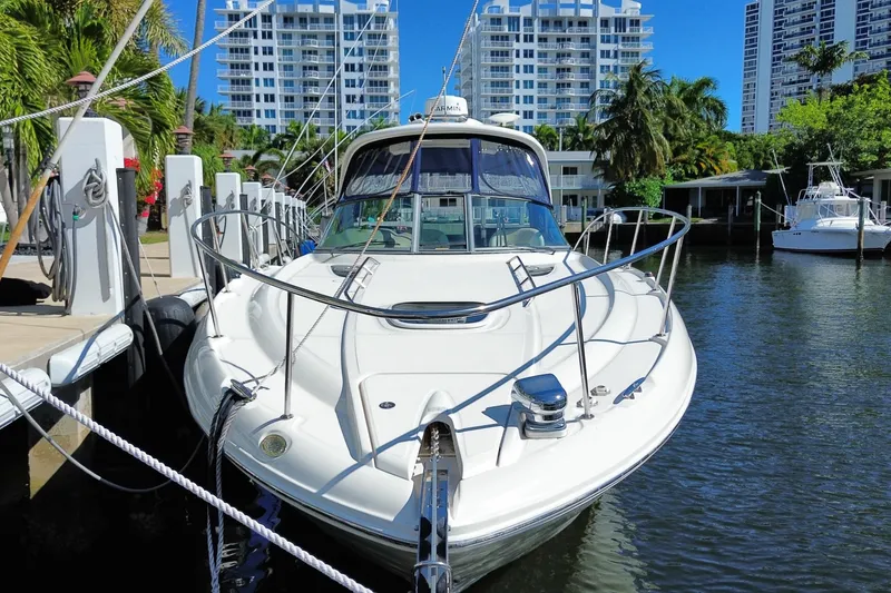 Slide: The Image of 2008 Sea Ray Sundancer 330 docked in a sunny marina with modern buildings. - 2