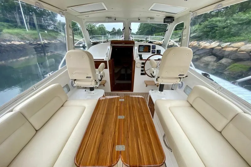 Slide: The Image of 2013 MJM 36z Downeast boat interior with plush seating and wooden table. - 16