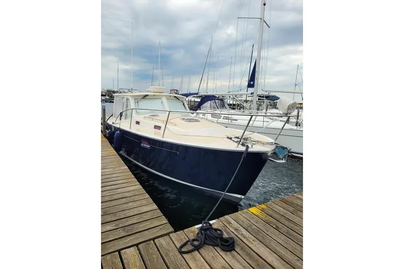 Slide: The Image of 2013 MJM 36z Downeast boat docked at a marina under cloudy skies. - 4