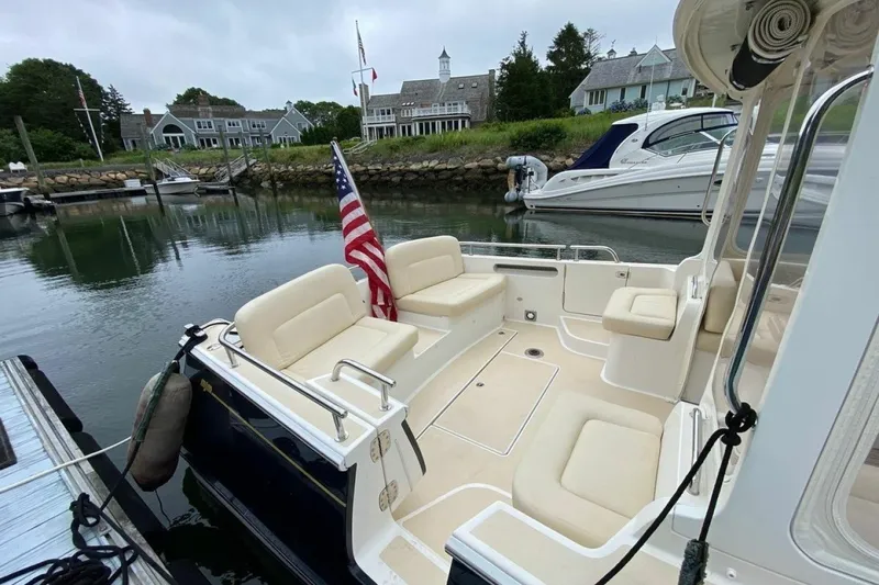 Slide: The Image of 2013 MJM 36z Downeast boat with American flag, docked near waterfront homes. - 8