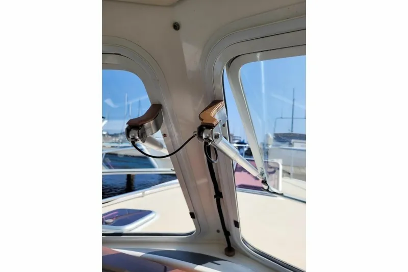 Slide: The Image of Interior view of a 2013 MJM 36z Downeast boat, showcasing window details and marina background. - 13