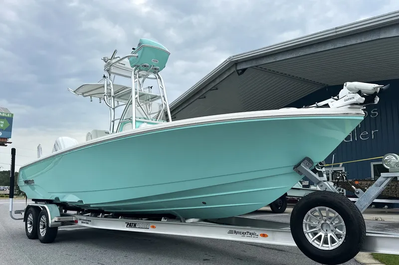 The Image of 2027 Pathfinder 2700 Tournament boat on trailer, turquoise hull, parked outdoors. - 0