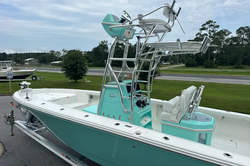 Slide: The Image of 2027 Pathfinder 2700 Tournament boat with teal accents on a trailer, parked outdoors. - 22
