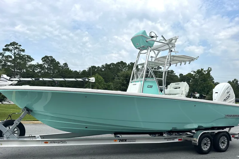 Slide: The Image of 2027 Pathfinder 2700 Tournament boat on trailer, mint green hull, parked outdoors. - 23