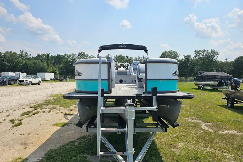 Slide: The Image of 2026 Bentley Pontoons 253 Elite Swingback DC on trailer, parked outdoors under a sunny sky. - 4