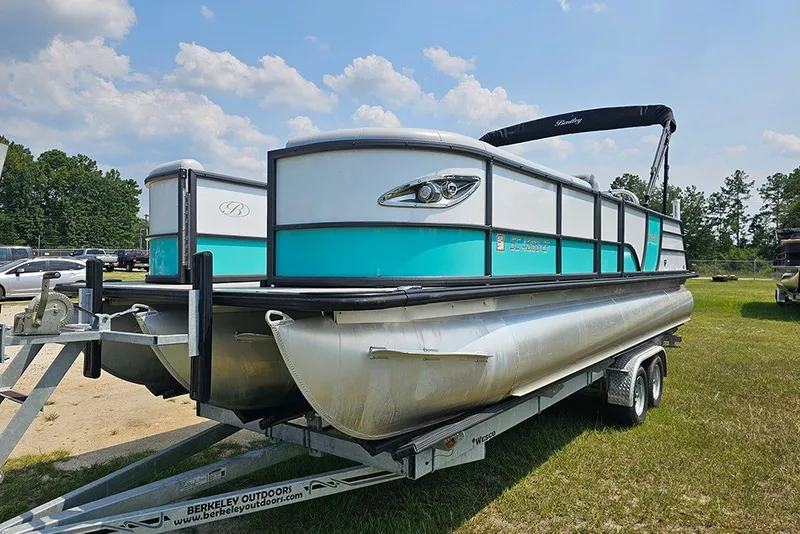 Slide: The Image of 2026 Bentley Pontoons 253 Elite Swingback DC on trailer, parked outdoors under a sunny sky. - 5