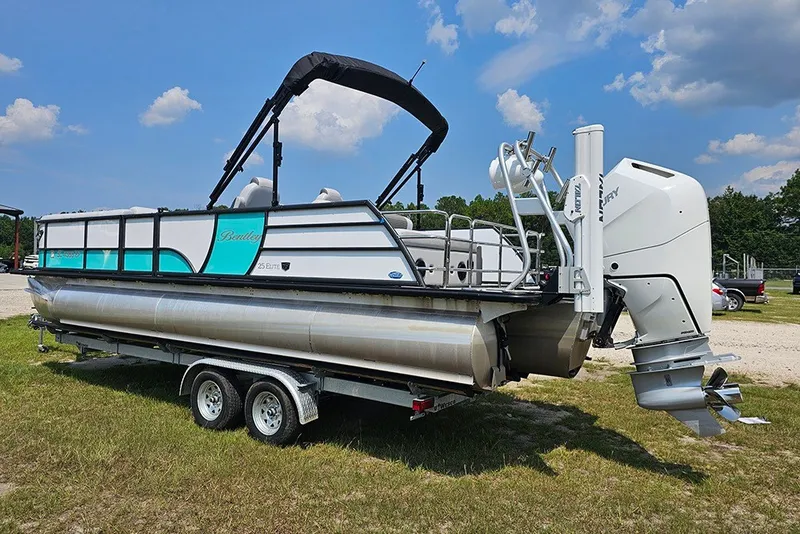 Slide: The Image of 2026 Bentley Pontoons 253 Elite Swingback DC on trailer, parked outdoors under blue sky. - 7