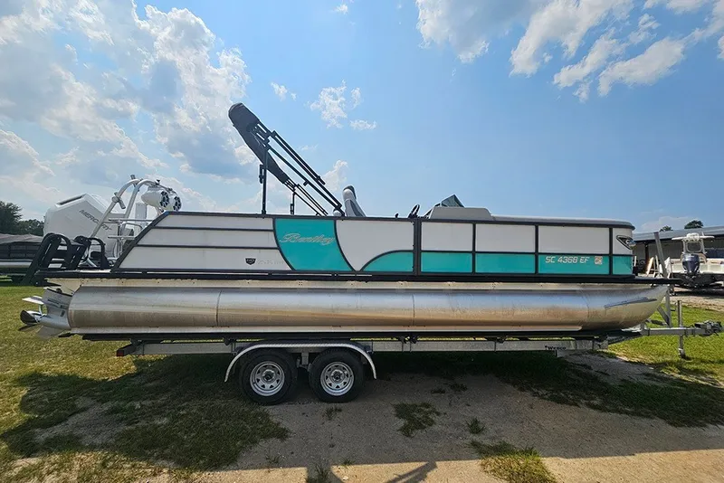 The Image of 2026 Bentley Pontoons 253 Elite Swingback DC on trailer under a sunny sky. - 1