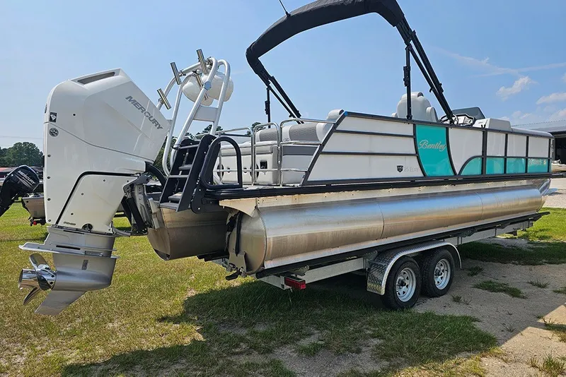 Slide: The Image of 2026 Bentley Pontoons 253 Elite Swingback DC on trailer, featuring Mercury outboard motor. - 3