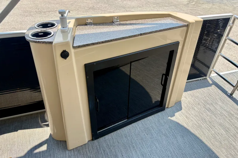 Slide: The Image of 2023 Sweetwater 2286 FSL boat interior with storage cabinet and cup holders. - 25
