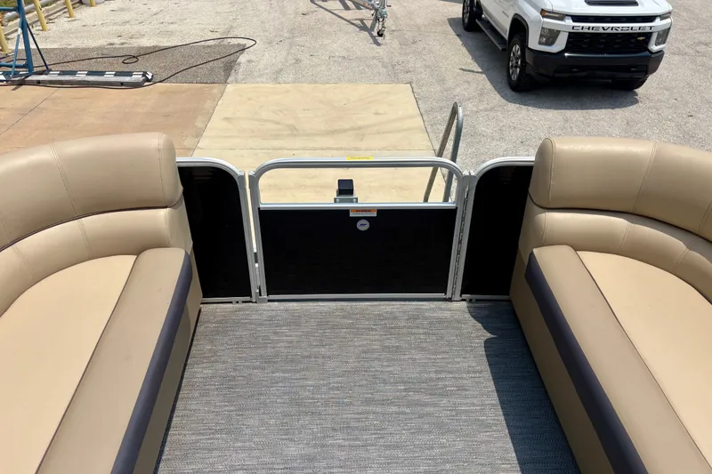 Slide: The Image of 2023 Sweetwater 2286 FSL pontoon boat interior with beige seating and open gate. - 37