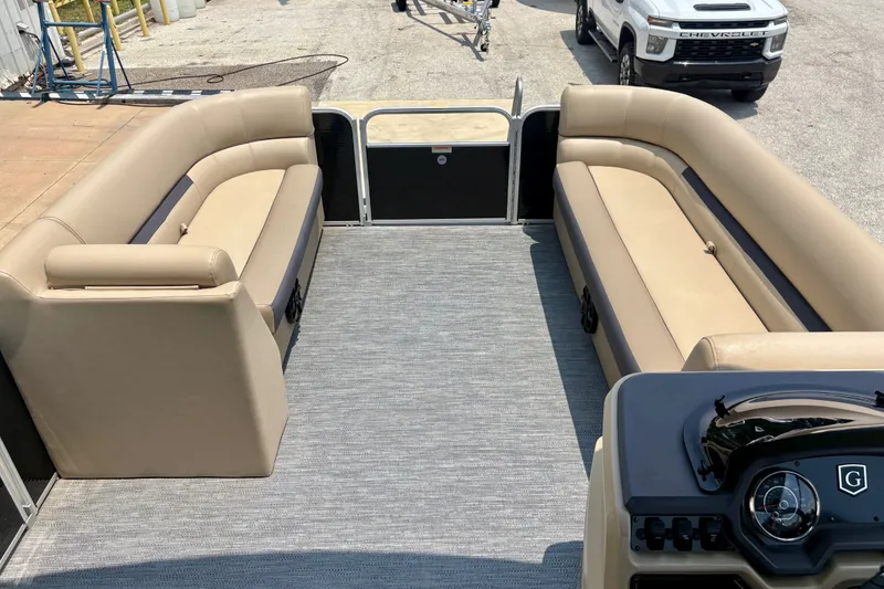 Slide: The Image of 2023 Sweetwater 2286 FSL pontoon boat interior with beige seating and steering console. - 27