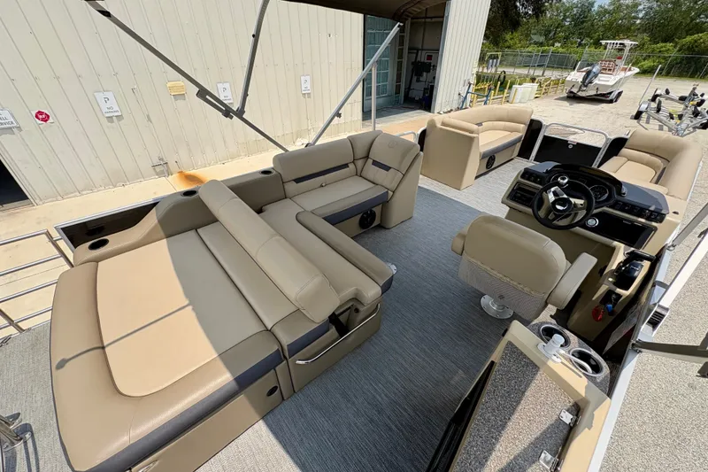Slide: The Image of 2023 Sweetwater 2286 FSL pontoon boat interior with beige seating and modern helm. - 38