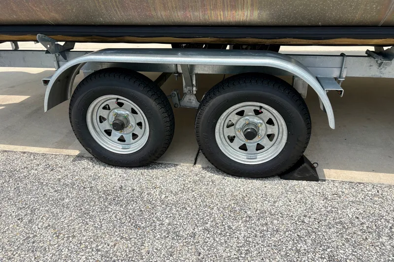 Slide: The Image of Trailer wheels of a 2023 Sweetwater 2286 FSL boat on pavement. - 49