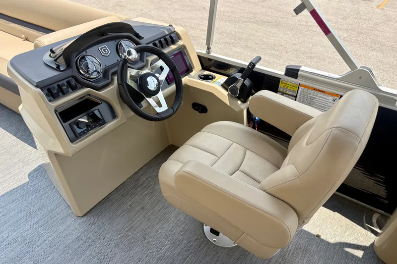 Slide: The Image of 2023 Sweetwater 2286 FSL boat helm with beige captain's chair and steering console. - 30