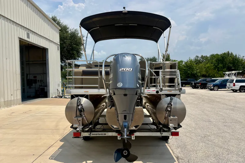 Slide: The Image of 2023 Sweetwater 2286 FSL pontoon boat with Yamaha 200 engine, parked outside a warehouse. - 7