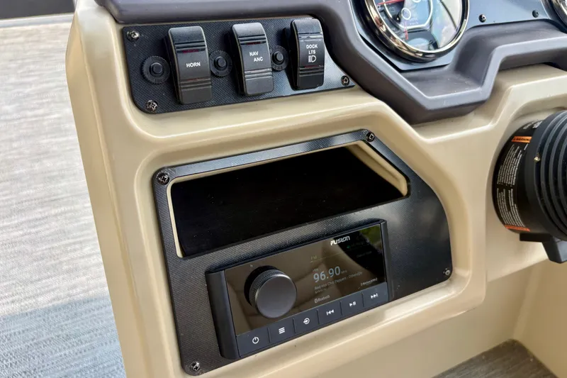 Slide: The Image of 2023 Sweetwater 2286 FSL boat dashboard with control switches and Fusion stereo system. - 32