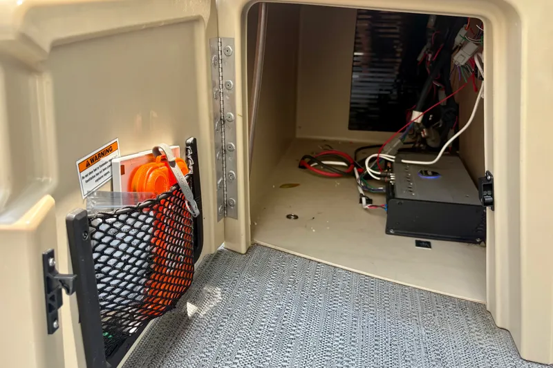 Slide: The Image of Interior storage compartment of 2023 Sweetwater 2286 FSL boat with wiring and safety equipment. - 46