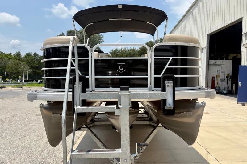 Slide: The Image of 2023 Sweetwater 2286 FSL pontoon boat on trailer, parked outside a warehouse. - 14