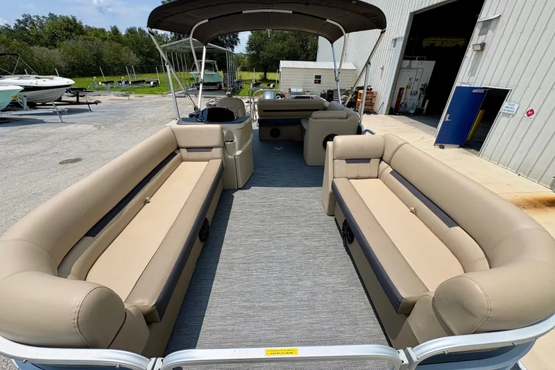 Slide: The Image of 2023 Sweetwater 2286 FSL pontoon boat with spacious seating and canopy in a marina setting. - 17