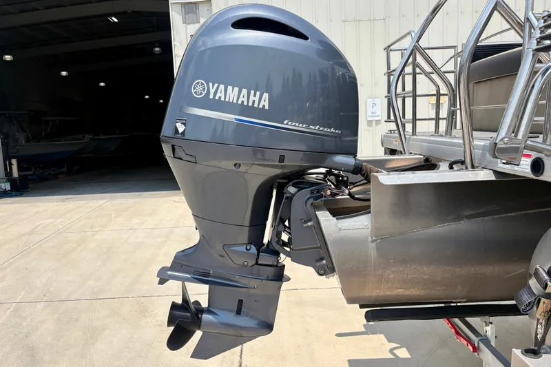 Slide: The Image of Outboard motor on 2023 Sweetwater 2286 FSL pontoon boat, parked outside a garage. - 10