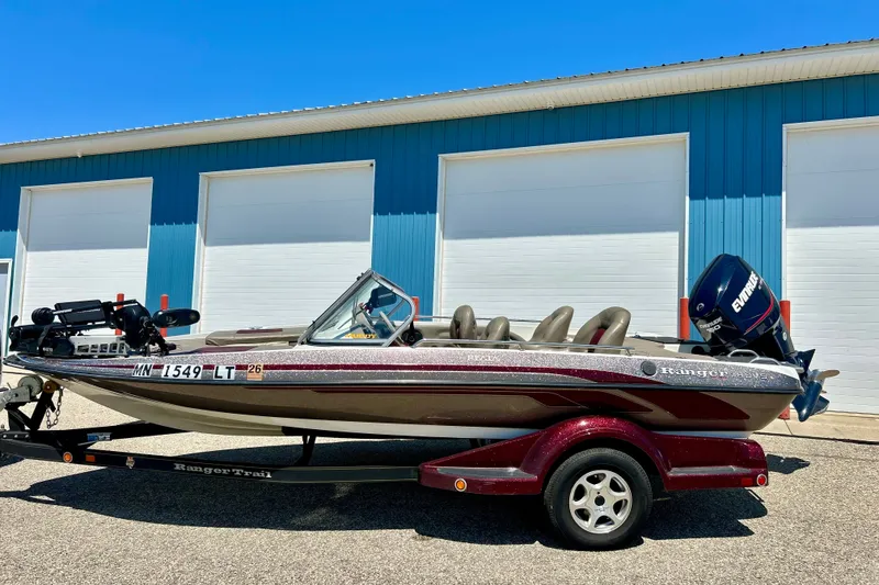 Slide: The Image of 2006 Ranger 180 Reata boat on trailer, parked outside blue building. - 5