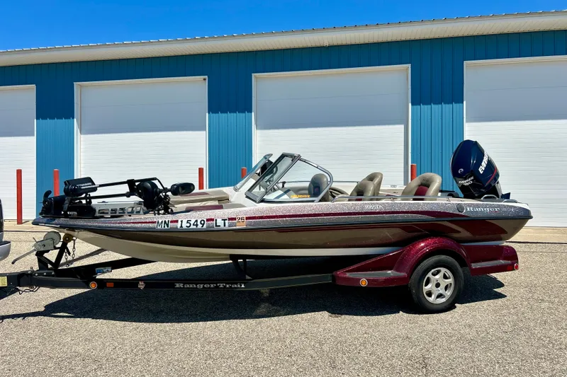 Slide: The Image of 2006 Ranger 180 Reata boat on trailer, parked in front of blue garage doors. - 3