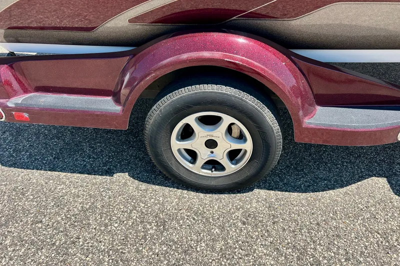 Slide: The Image of 2006 Ranger 180 Reata trailer wheel with maroon fender on asphalt surface. - 11